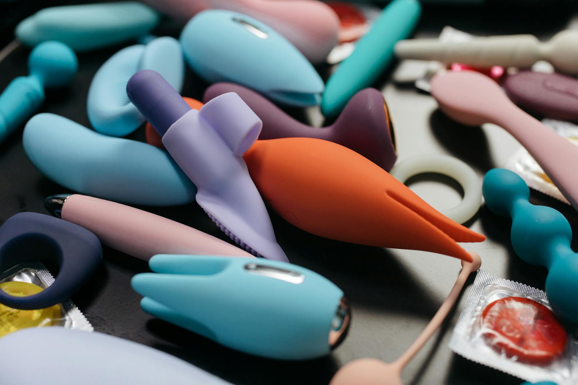 Colorful clitoral vibrators arranged on a bright yellow background, representing diverse pleasure options