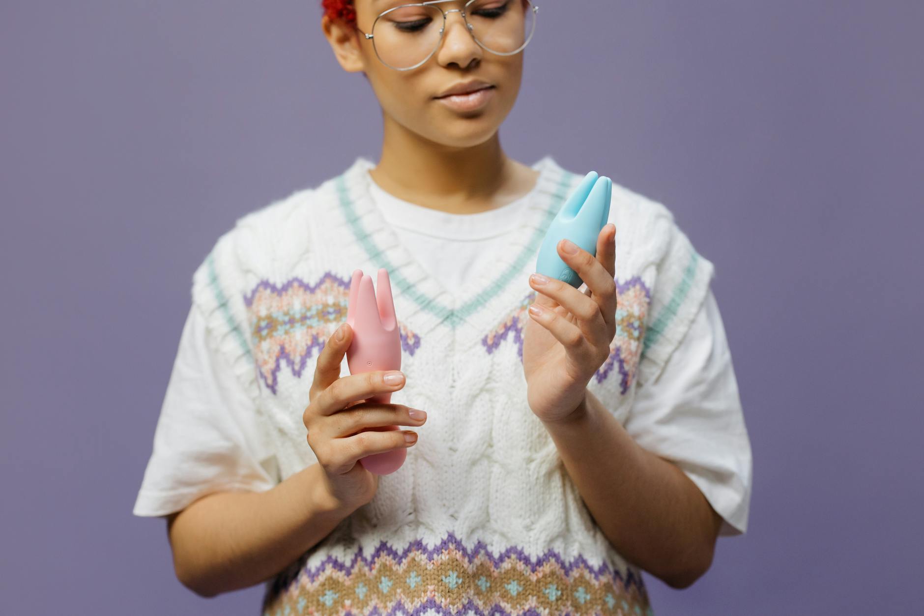 Woman holding blue and pink silicone vibrators, exploring pleasure during hormonal changes