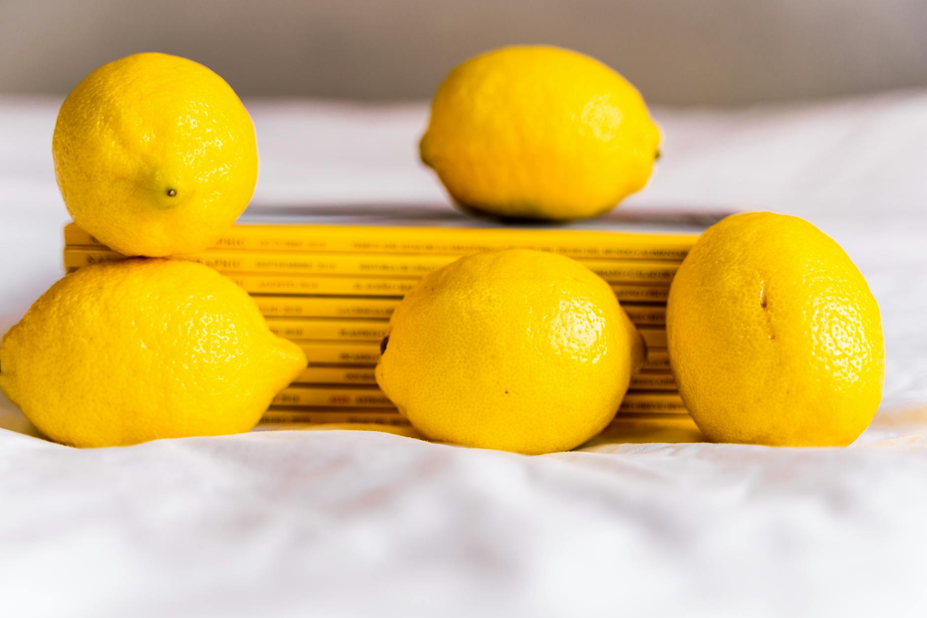 Fresh lemons stacked with books on white tablecloth, symbolizing a slower, more intentional approach to pleasure
